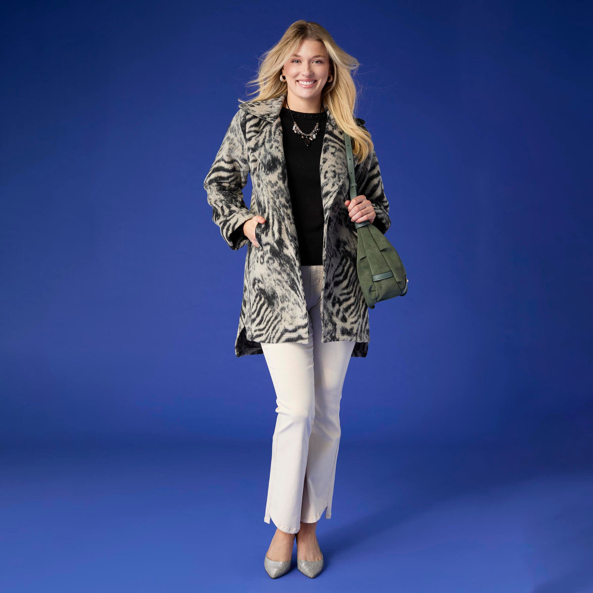 Willa Curved Hem Flare Pant, A woman's lower half in cream flare pants with a curved hem and pointed cream ankle boots.