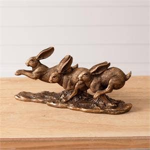Figura de liebres doradas saltando