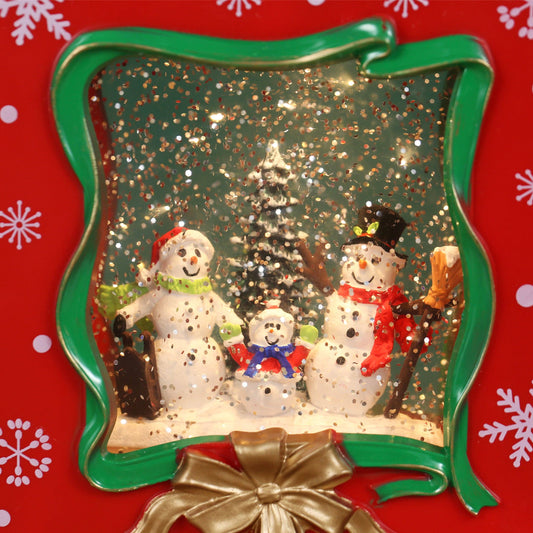 Bolsa de regalo musical navideña roja con forma de bola de nieve y escena familiar de muñeco de nieve para decoración navideña.