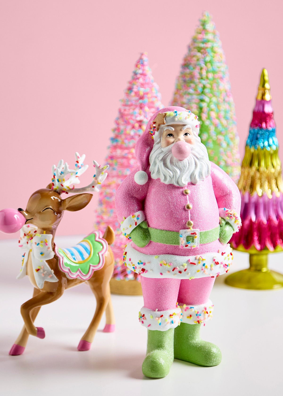 Bubblegum Blowin' Reindeer, A brown reindeer figurine blowing a pink bubblegum bubble, with sprinkle dusted antlers, a candy striped saddle blanket, a sprinkle covered neck bow, and pink hooves.