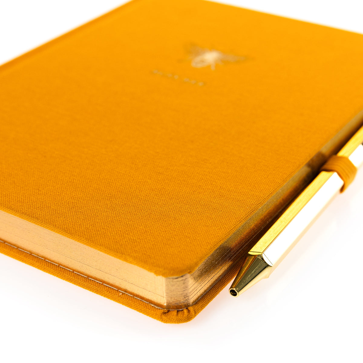 La Petite Presse Bee Fabric-Bound Journal with Pen, A marigold fabric journal with a gold foil bee and the words Busy Bee on the cover, paired with a gold twist pen.