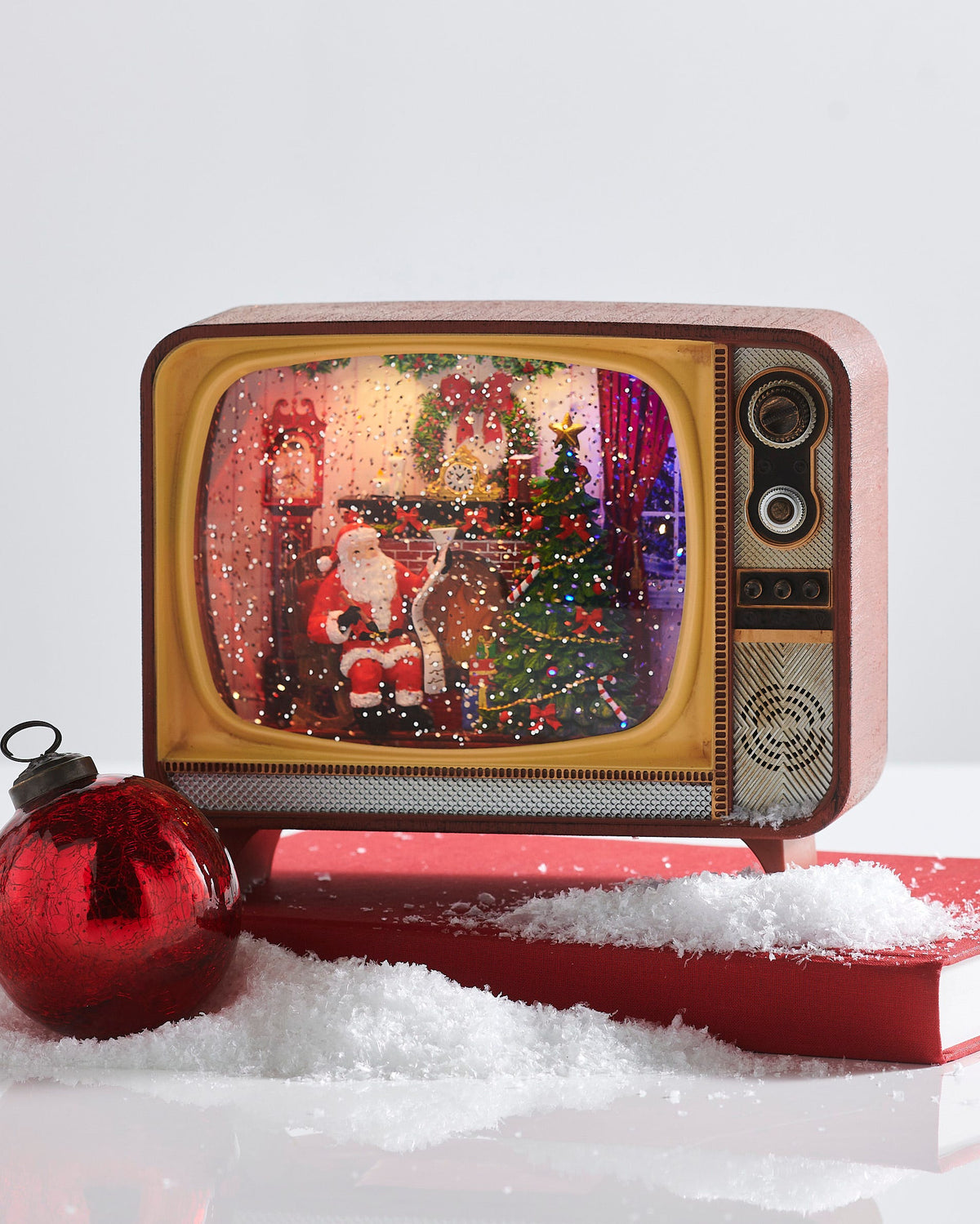 Fireplace Santa Musical Lighted Water TV, A vintage-style television shaped water lantern showing a glitter filled scene of Santa reading a list by a decorated fireplace and Christmas tree.