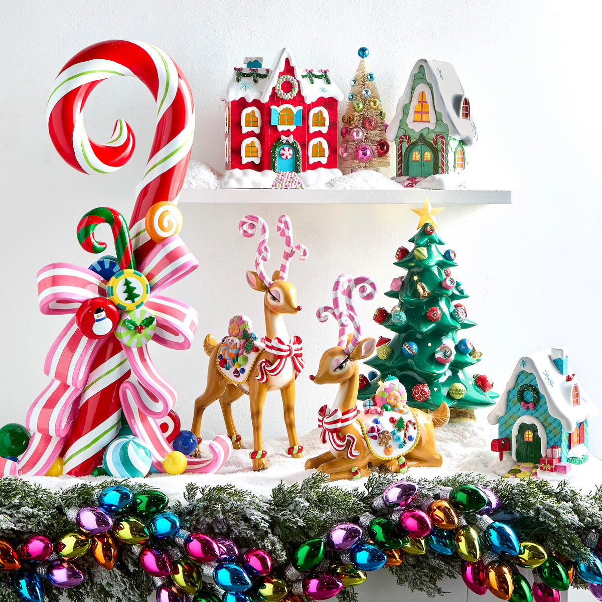 Lighted Tabletop Christmas Tree with Ornaments, A glossy green tabletop Christmas tree dotted with small lights and ornaments in red, pink and teal, with gold bells, a gold star on top and a gold star-shaped base.
