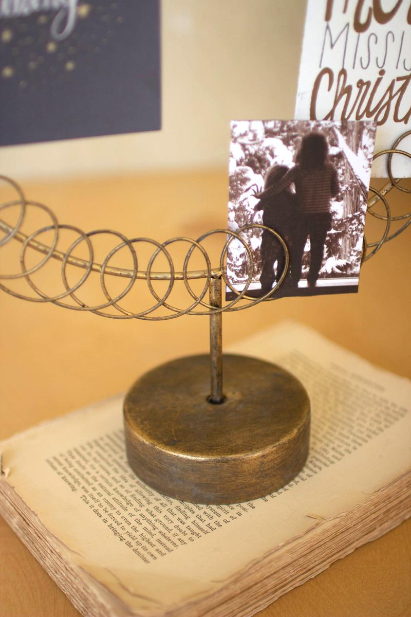 Round Wire Christmas Card Holder on a Stand, A round wire card holder on a stand with cards tucked into the wire.