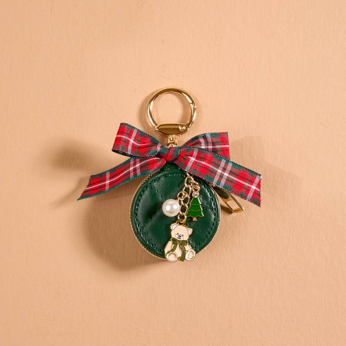 Travel Jewelry Case Bag Charm, A tan round zip case charm with a green gingham bow, a pearl, a gold bee, and a honeycomb charm, in the Hey Honey design.
