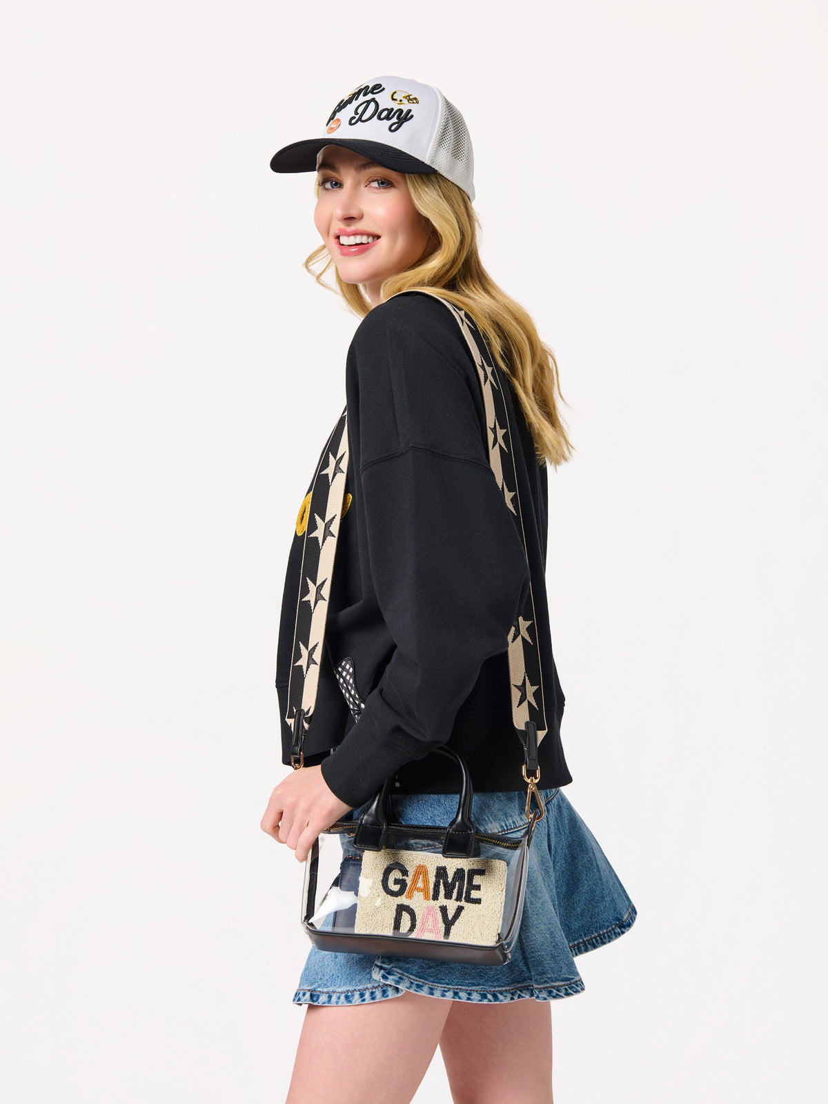 Spectator Clear Stadium Top Handle Cross-Body Bag, Black, A clear PU bag with black handles and gold hardware, with a long black and cream star-patterned strap hanging above it.