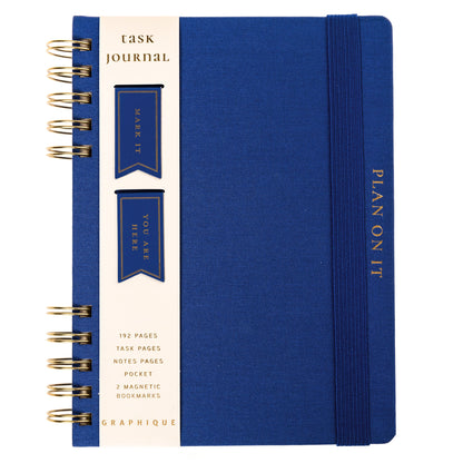 Cobalt Blue Fabric-Bound Task Journal, A cobalt blue fabric-covered task journal with gold twin wire spirals and two navy ribbon bookmark tabs, closed with an elastic band.