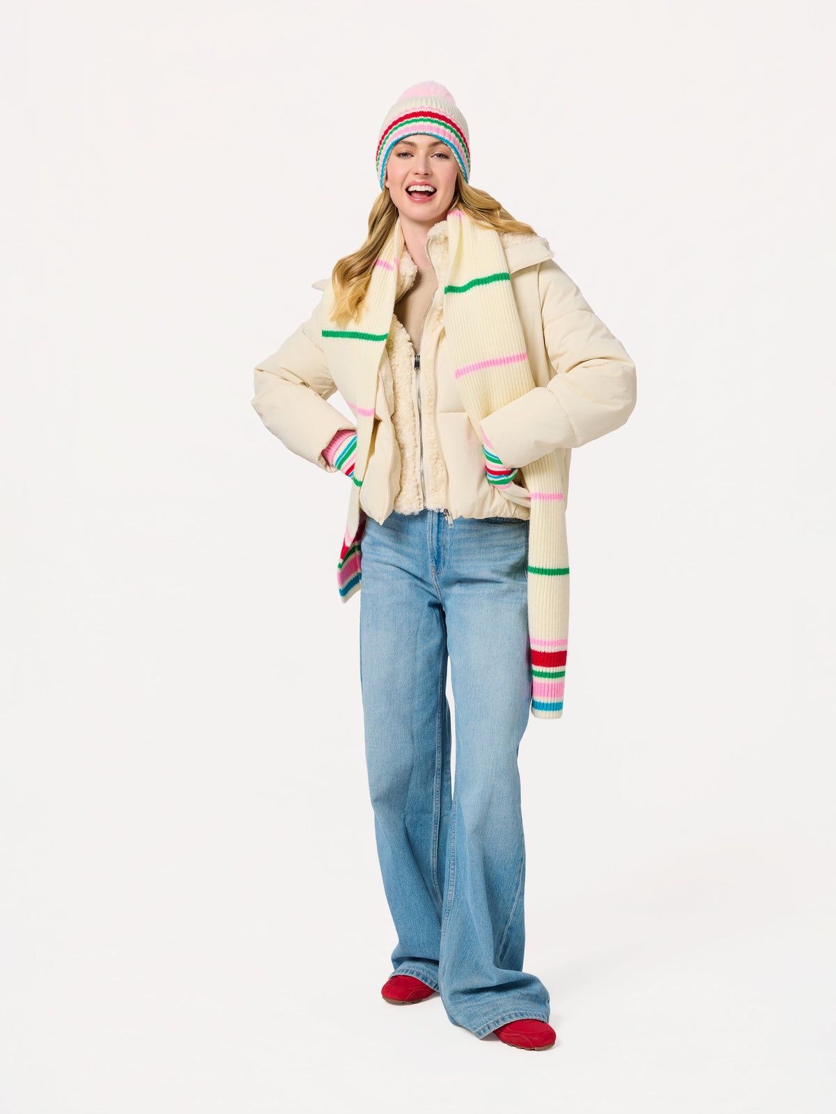 Elle Beanie, Ivory, A cream ribbed knit beanie with a fluffy pink pom-pom and a folded cuff striped in pink, red, green and blue.