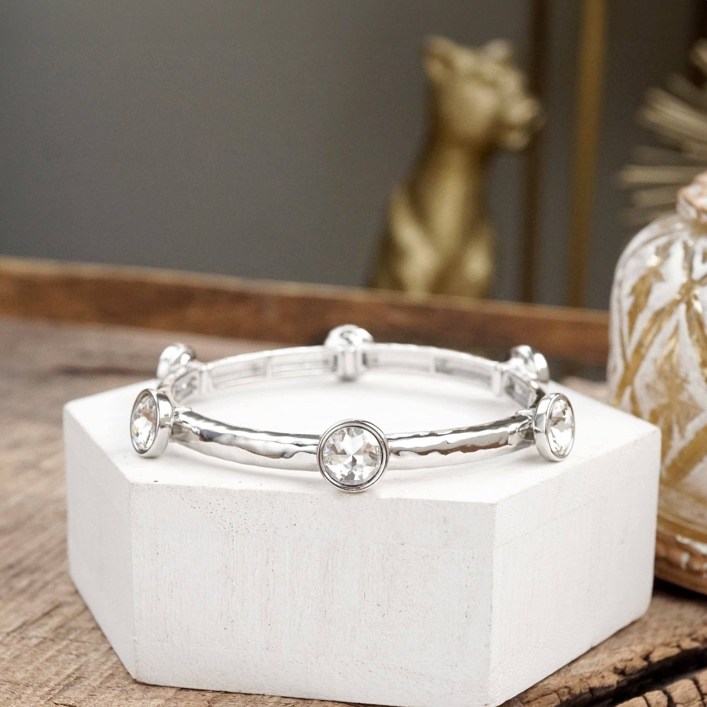 Brazalete de cristales transparentes brillantes en tono dorado o plateado.