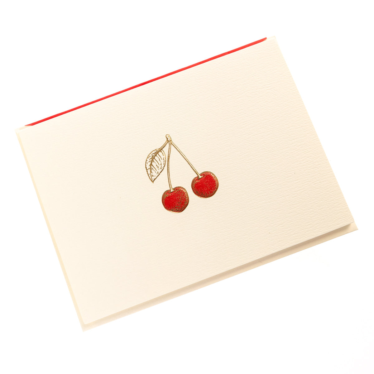 La Petite Presse Cherries Boxed Correspondence Notes, An ivory notecard with gold foil cherries filled in red glitter, paired with a cream envelope lined in bright red.