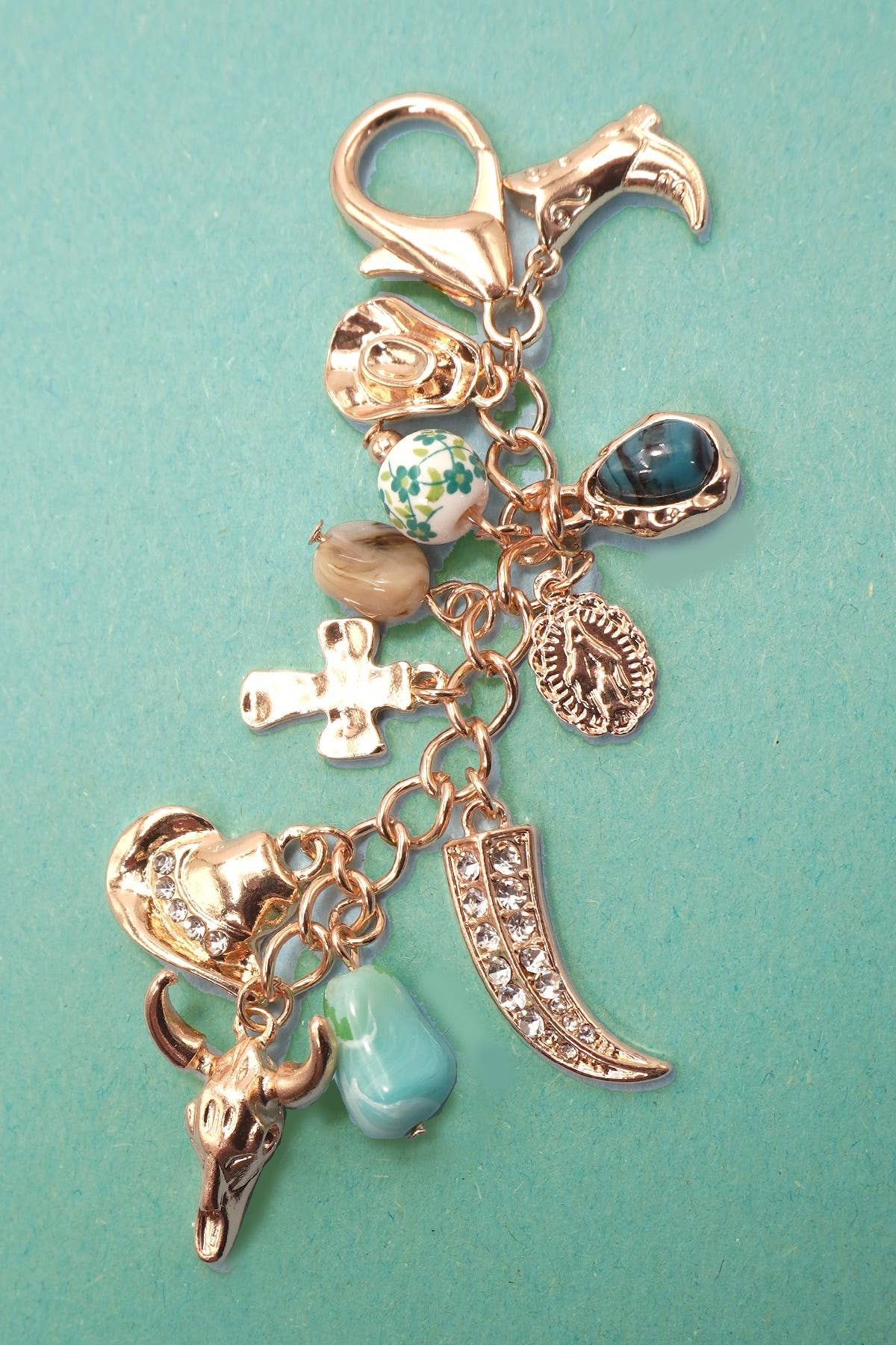 DIJE PARA BOLSO CON SOMBRERO VAQUERO Y BOTA CRUZADA DE PORCELANA OCCIDENTAL