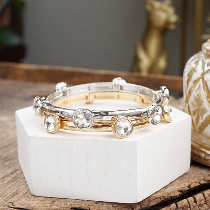 Brazalete de cristales transparentes brillantes en tono dorado o plateado.