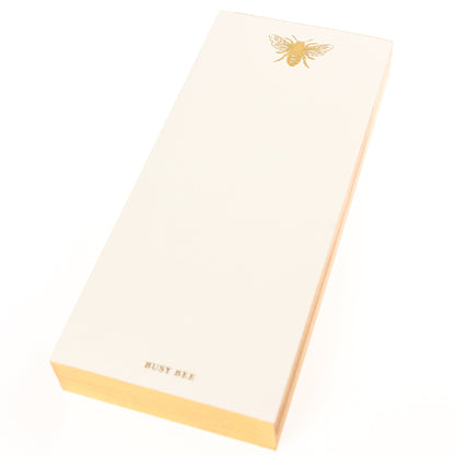La Petite Presse Bee Gilded Desktop Notepad, A cream notepad with a gold foil bee at the top and the words Busy Bee stamped in gold at the bottom, with a gold gilded edge.