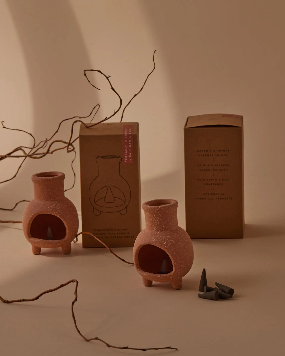 Palo Santo & Sage Chiminea Incense Holder, A terracotta ceramic chiminea shaped incense holder standing next to its kraft packaging box labeled Palo Santo and Sage.
