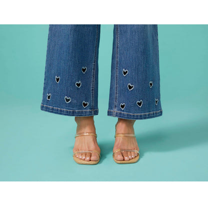 Bambu Soft Heart Cut-Out Wide Leg Ankle Jeans, A woman in medium denim wide leg ankle jeans with heart cut-outs along the hems, a lavender top and braided sandals.
