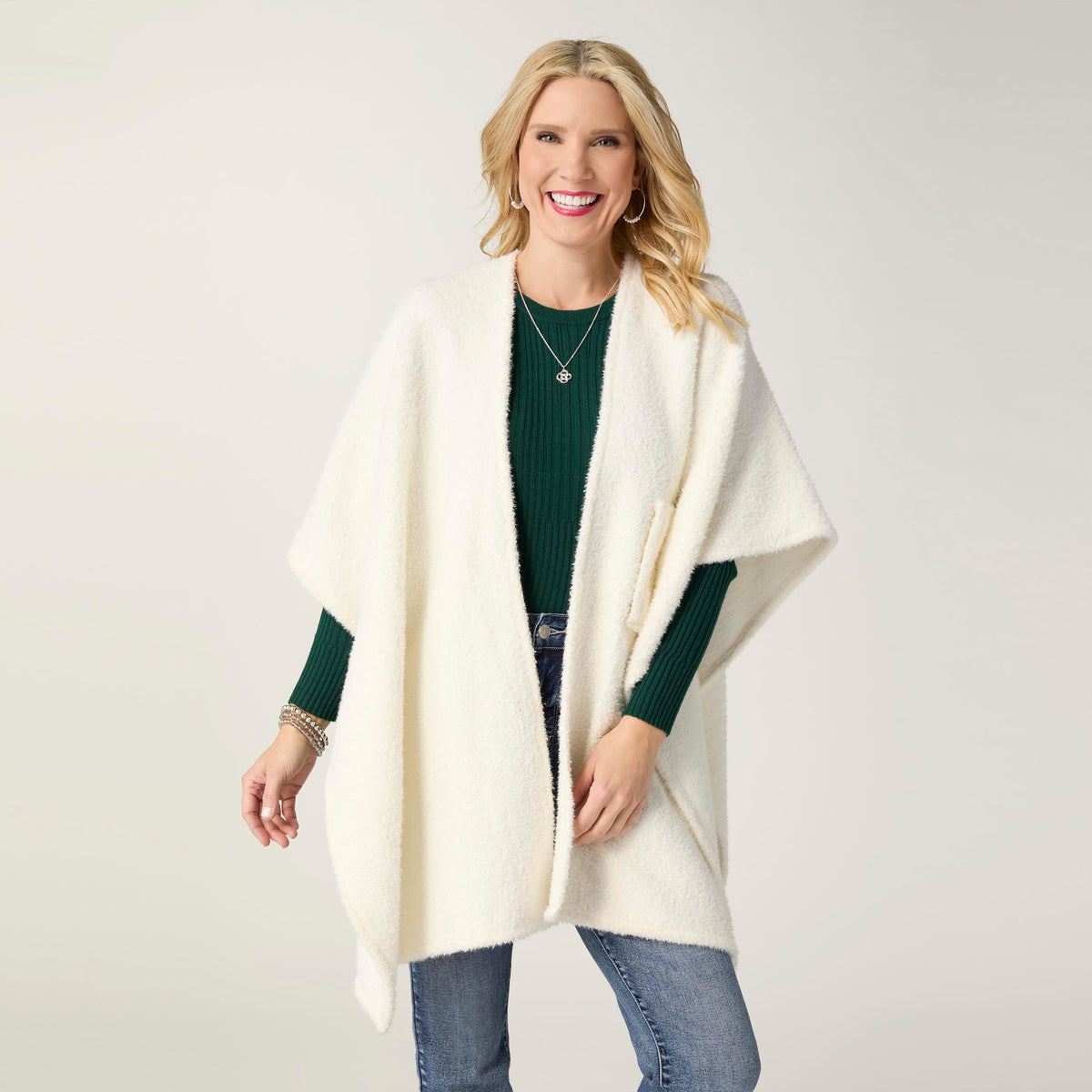 Elaina Tinsel Pull-Through Wrap, A smiling woman wears a soft white textured knit ruana wrap with one end pulled through a front loop into a twisted knot.