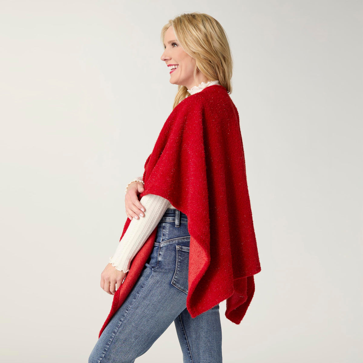 Elaina Tinsel Pull-Through Wrap, A smiling woman wears a soft white textured knit ruana wrap with one end pulled through a front loop into a twisted knot.