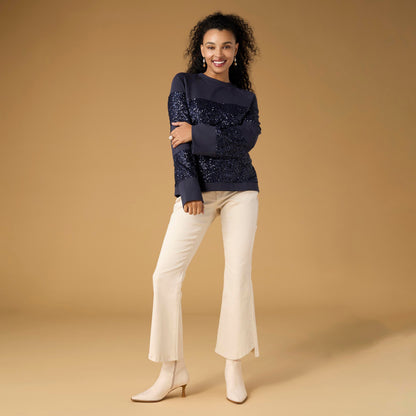 Willa Curved Hem Flare Pant, A woman's lower half in cream flare pants with a curved hem and pointed cream ankle boots.