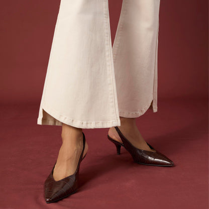 Willa Curved Hem Flare Pant, A woman's lower half in cream flare pants with a curved hem and pointed cream ankle boots.