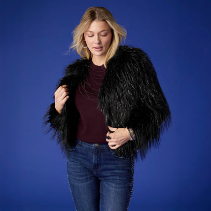 Raven Tinsel Faux Fur Jacket, A smiling woman in a cropped black faux fur jacket with silver tinsel strands over a gray top and blue jeans.