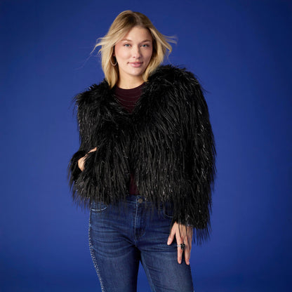 Raven Tinsel Faux Fur Jacket, A smiling woman in a cropped black faux fur jacket with silver tinsel strands over a gray top and blue jeans.