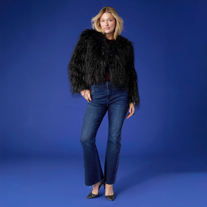 Raven Tinsel Faux Fur Jacket, A smiling woman in a cropped black faux fur jacket with silver tinsel strands over a gray top and blue jeans.