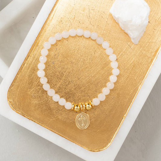 Pulsera de piedra elástica con dije de cruz ovalada