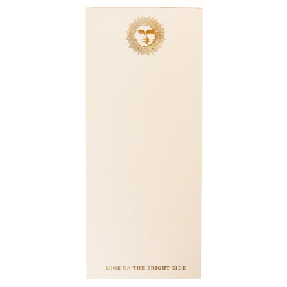 La Petite Presse Sun Gilded Desktop Notepad, A cream notepad with a gold foil sun and face design at the top and the words Look on the Bright Side stamped in gold at the bottom.
