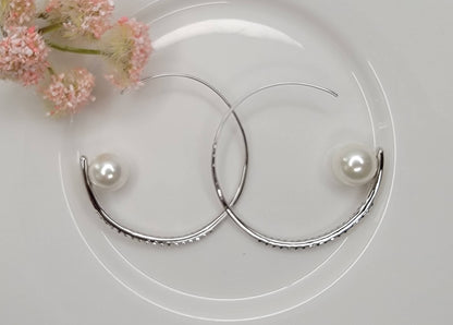 HOOP EARRING EMBEDDED WITH STONE LEADING TO A PEARL PERCHED