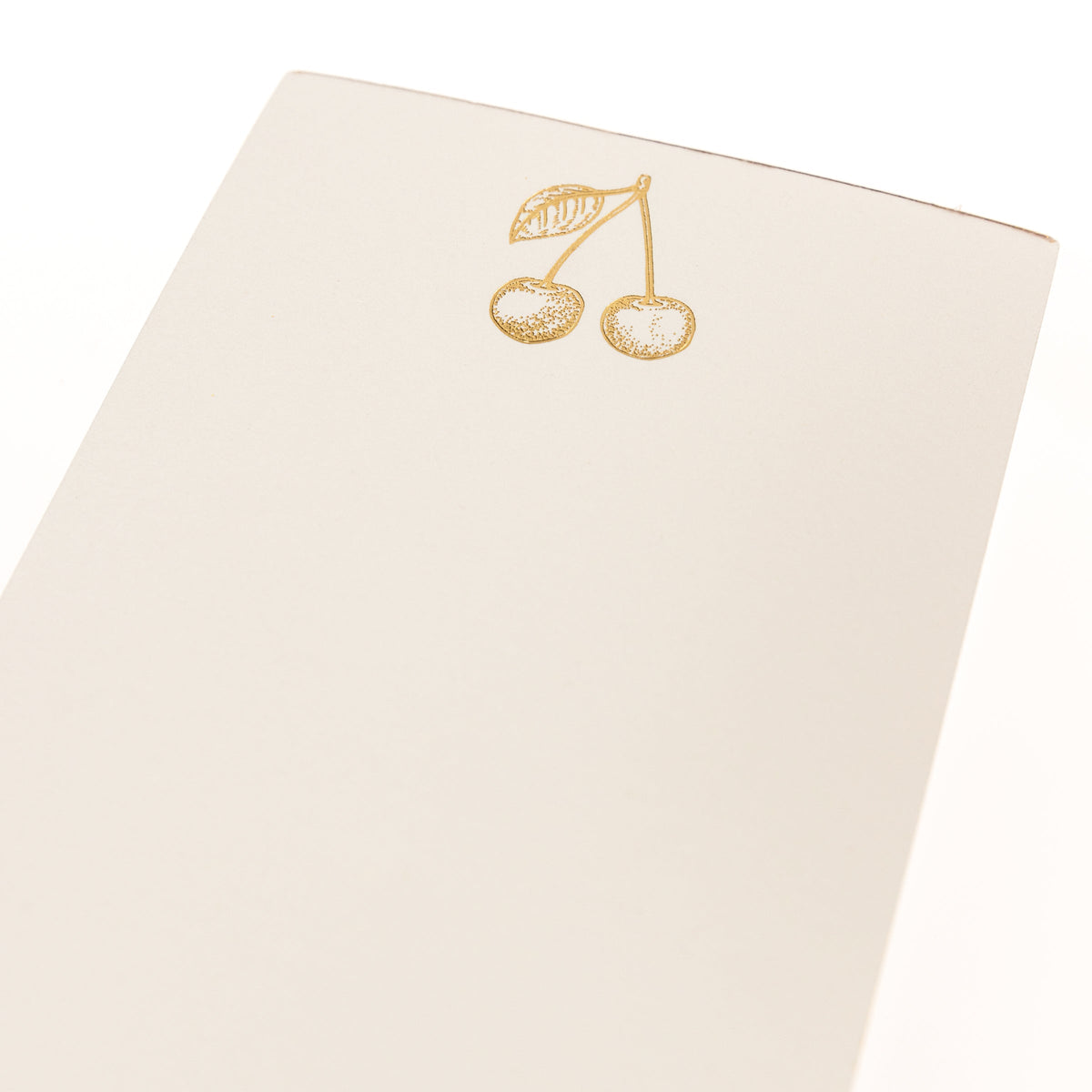 La Petite Presse Cherries Gilded Desktop Notepad, A cream notepad with gold foil cherries at the top and the words Cherish the Little Things stamped in gold at the bottom.