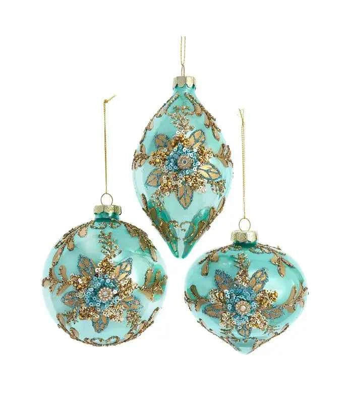 An aqua glass ornament decorated with a gold sequin and bead flower with an aqua sequin center.