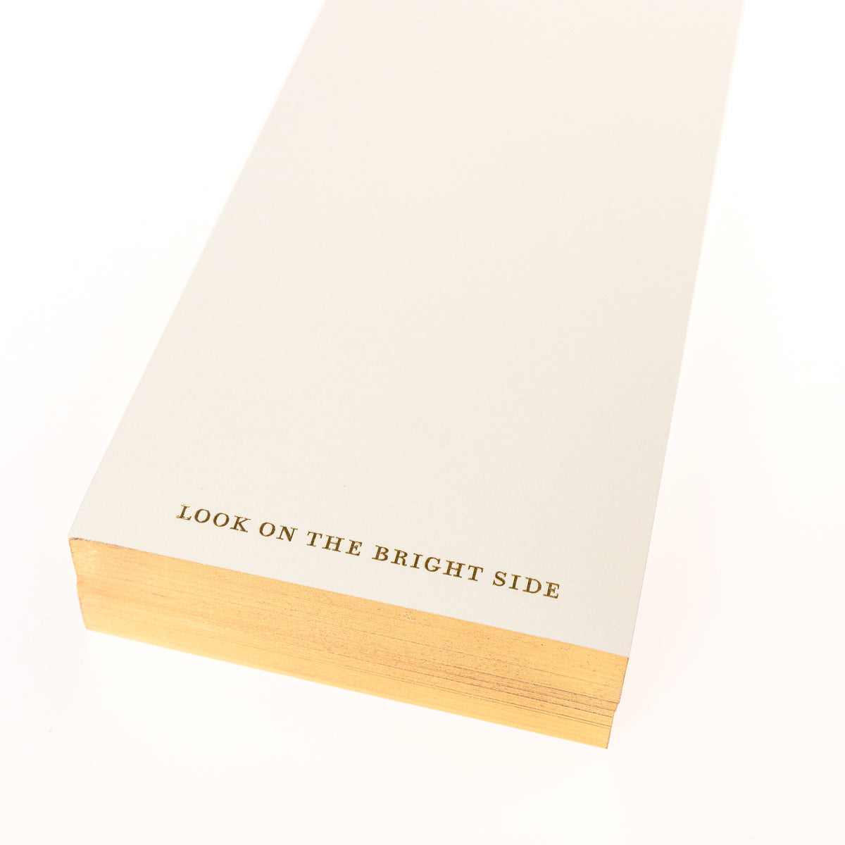 La Petite Presse Sun Gilded Desktop Notepad, A cream notepad with a gold foil sun and face design at the top and the words Look on the Bright Side stamped in gold at the bottom.