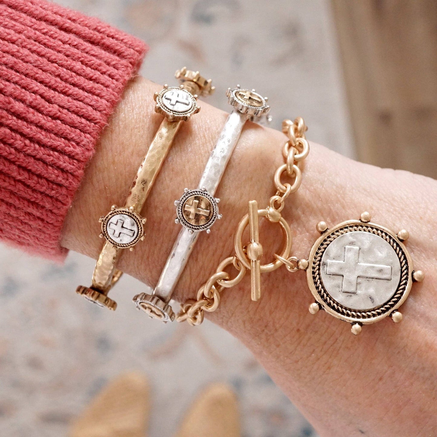 Pulsera de cadena con monedas cruzadas y cierre de palanca en tono plateado o dorado