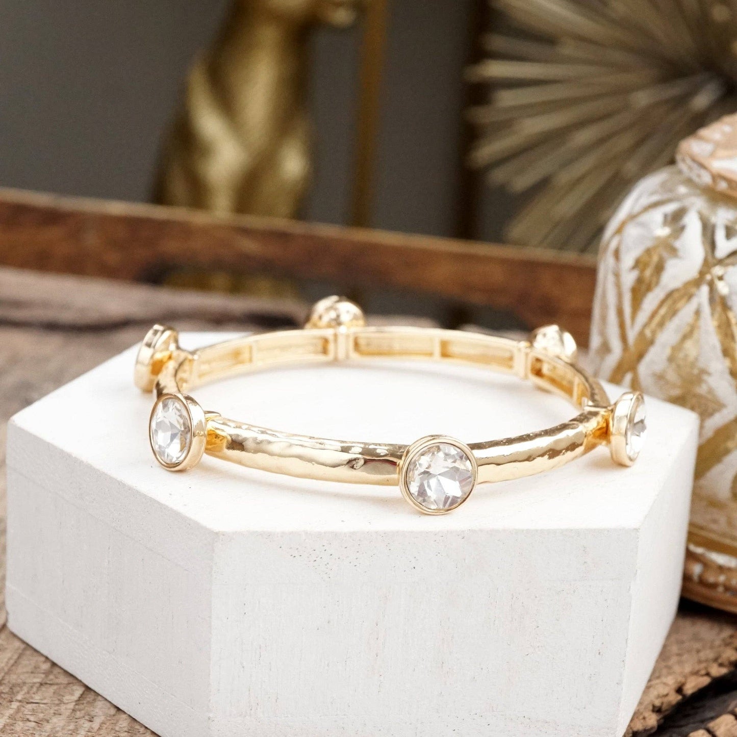Brazalete de cristales transparentes brillantes en tono dorado o plateado.