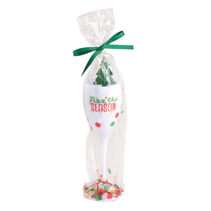 Fizz the Season Acrylic Champagne Flute and Stirrer, A white acrylic champagne flute printed with Fizz the Season and red and green confetti dots, holding a green glitter tree stirrer, wrapped in cellophane tied with a green bow.
