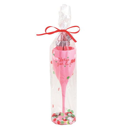 Let's Get Lit Acrylic Champagne Flute and Stirrer Set, A pink acrylic champagne flute lettered Let's get lit in red, wrapped in a cello sleeve with red and green confetti and a stirrer, tied with a red ribbon.