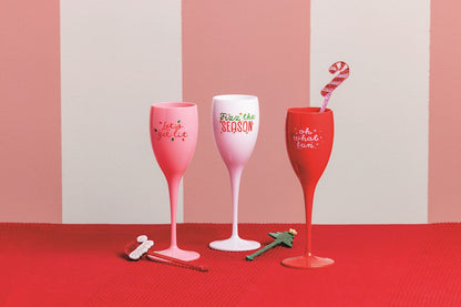 Let's Get Lit Acrylic Champagne Flute and Stirrer Set, A pink acrylic champagne flute lettered Let's get lit in red, wrapped in a cello sleeve with red and green confetti and a stirrer, tied with a red ribbon.