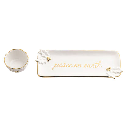 Gold Holly Tray and Tidbit Bowl Set, A long white stoneware tray lettered peace on earth in gold with sculpted holly leaves and gold berries, shown beside a small scalloped bowl with a gold rim.