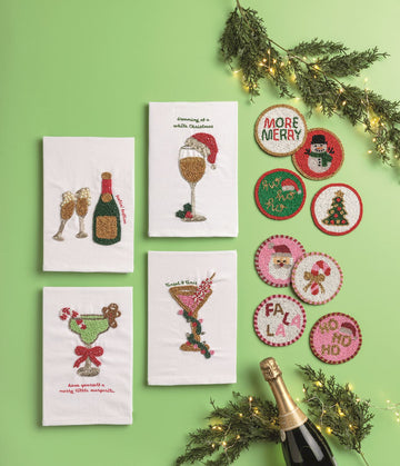 Feelin' Festive Beaded Champagne Hand Towel, A cream cotton hand towel beaded with a green champagne bottle with a gold label and two flutes with pearl bubbles, with feelin' festive embroidered in red script.
