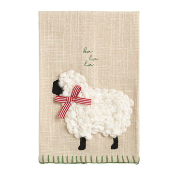 Christmas Sheep Embroidered Farm Hand Towel, An oatmeal slub hand towel with a sheep worked in looped white yarn, a black face and legs, a red and white striped ribbon bow, baa la la in green script and a green whipstitched hem.