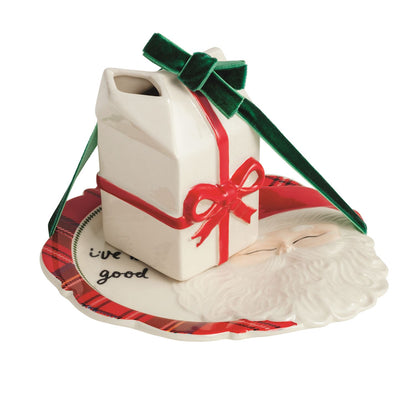 Dear Santa Cookie Plate and Milk Carton Set, A stoneware plate with a raised sculpted Santa face and tartan hat brim, hand-lettered script on the rim, shown with a stoneware milk carton tied with a green velvet ribbon.