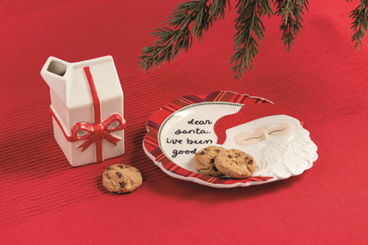 Dear Santa Cookie Plate and Milk Carton Set, A stoneware plate with a raised sculpted Santa face and tartan hat brim, hand-lettered script on the rim, shown with a stoneware milk carton tied with a green velvet ribbon.