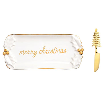 Gold Holly Butter Dish and Spreader Set, A white stoneware butter dish with sculpted holly leaves at each end, gold berries, a gold rim and merry christmas in gold script, shown with a gold spreader with a Christmas tree handle.