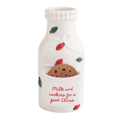 Milk and Cookies Ceramic Bottle with Cookie Pocket, A white ceramic milk bottle with a beaded rim and raised red and green light bulbs, a front pocket holding a chocolate chip cookie and red script reading Milk and cookies for a good Claus.