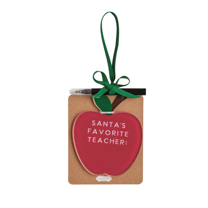 Santa's Favorite Teacher Apple Ornament with Marker, A red apple shaped acrylic ornament reading Santa's Favorite Teacher with a green ribbon hanger, mounted on a kraft card with a black marker tucked behind the bow.