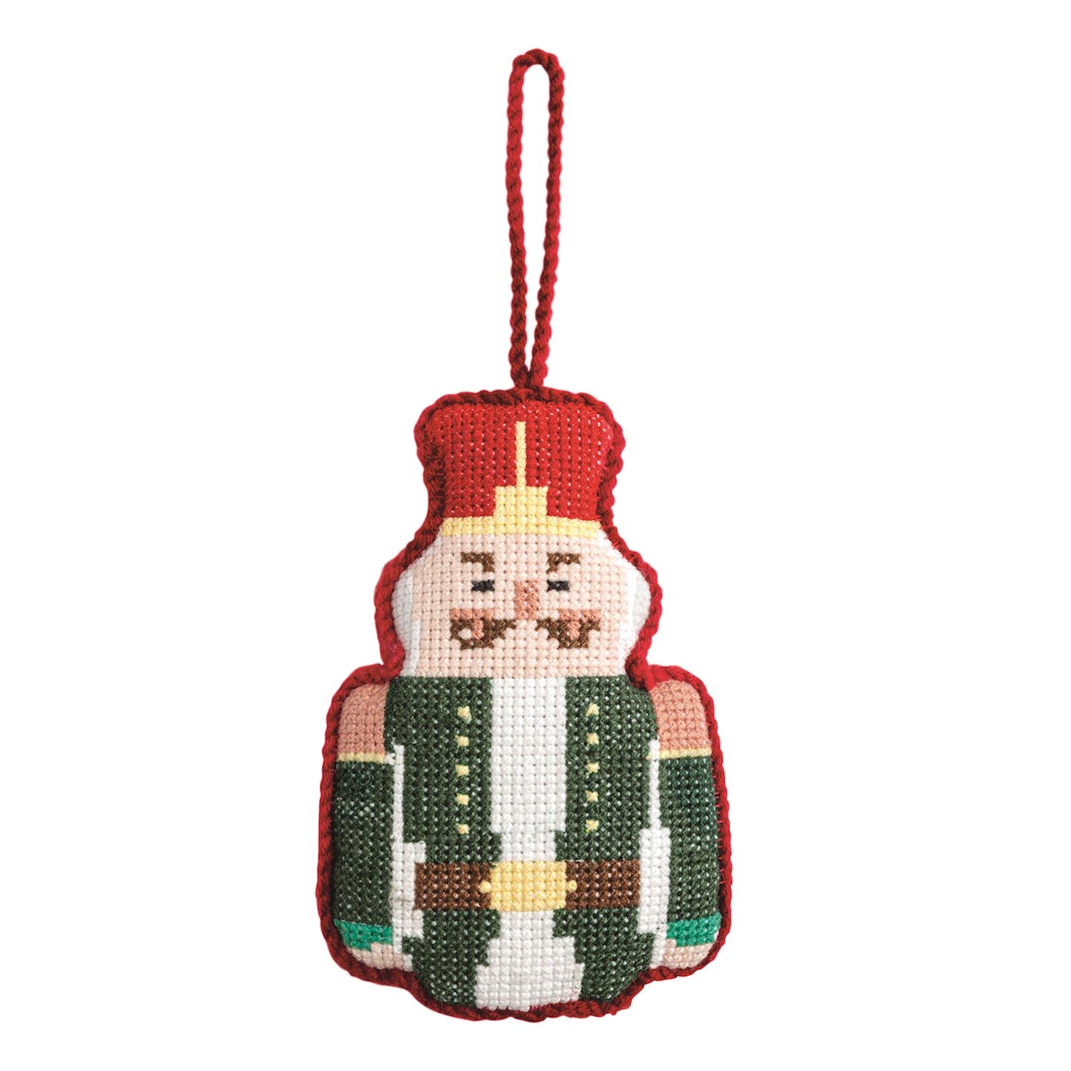 Nutcracker Needlepoint Ornament, Needlepoint ornament of a nutcracker soldier in a red hat and green jacket with a brown belt and white beard, edged in red whipstitch and hung from a red cord loop.