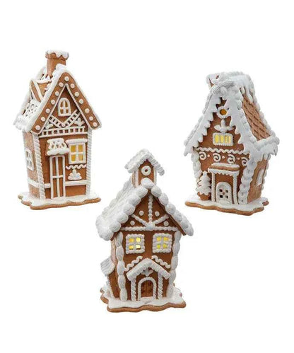 A gingerbread house piped in white royal icing, lit warm white from inside.
