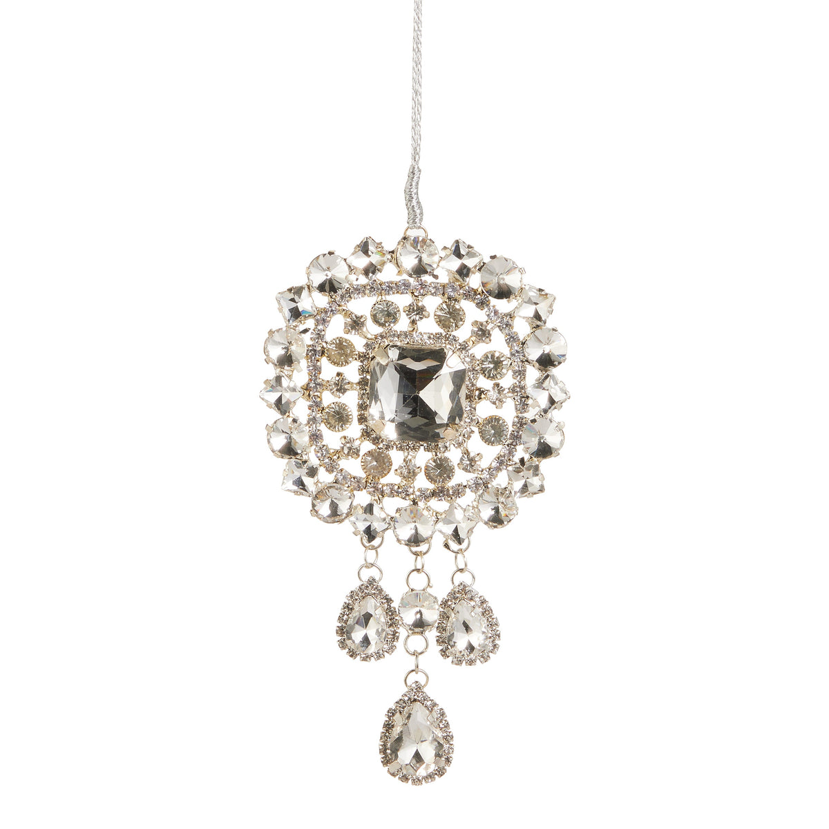 5" Gem Brooch Ornament, A round faceted brooch shaped ornament with a large center stone framed by smaller stones and three teardrop stones hanging below on a cord.