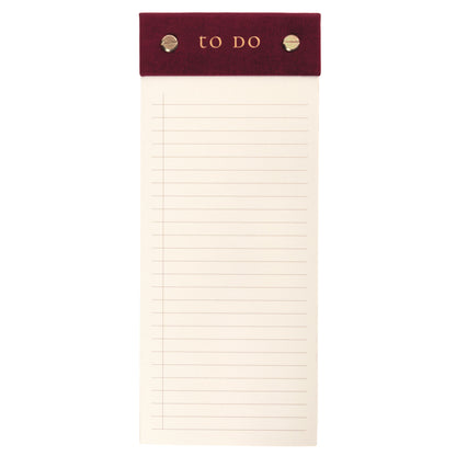 Burgundy Fabric-Bound Desktop Notepad, A burgundy fabric desktop notepad with to Do lettered in gold foil and two gold posts at the top.