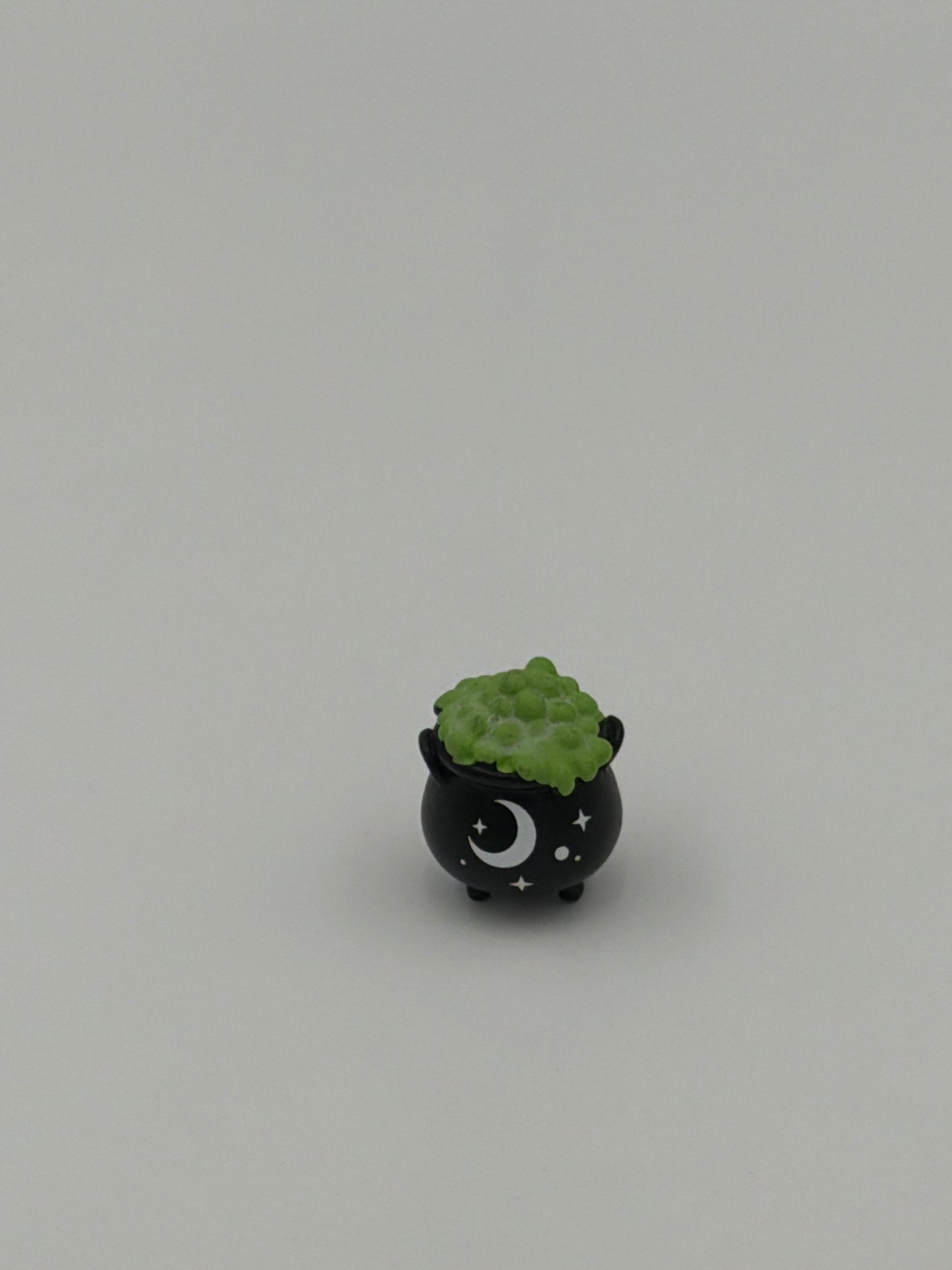 Charm de bolsillo que brilla en la oscuridad con forma de caldero de bruja